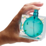 hand holding a perfume bottle that is square and turquoise